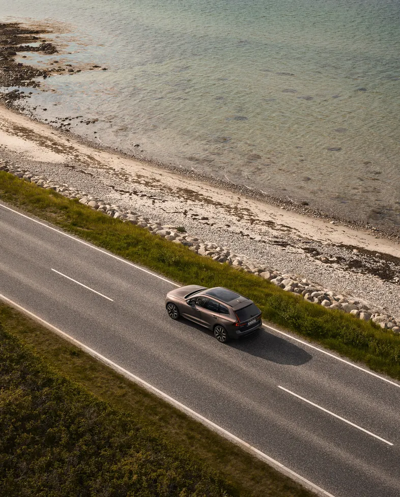 Vista aérea de um Volvo em uma estrada à beira-mar